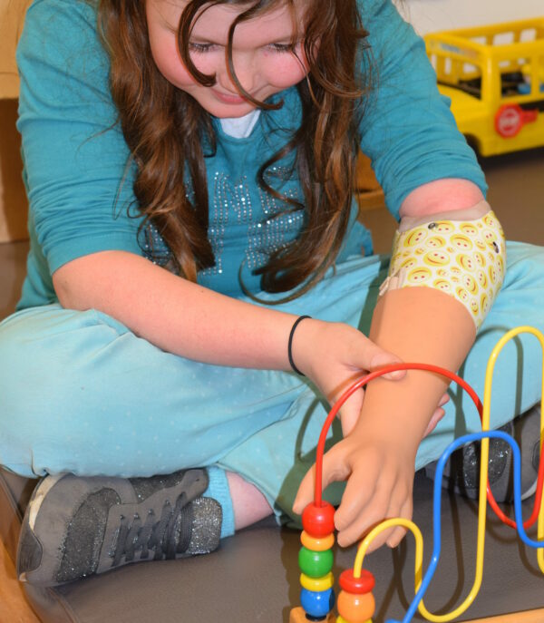 Kind met armprothese aan het spelen