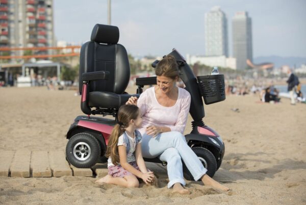 Mama met scooter en haar dochter op het strand