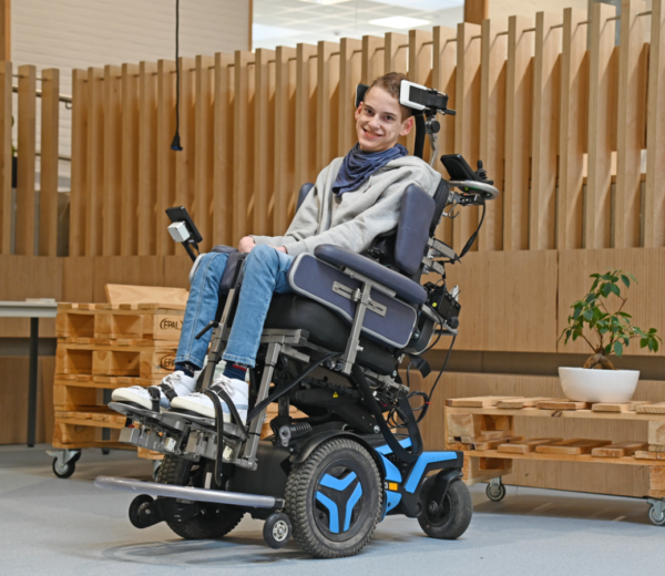 Man in rolstoel met hoofd-voetbesturing