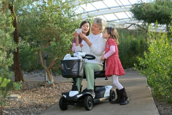 Vrouw op haar scooter met kinderen aan haar zijde