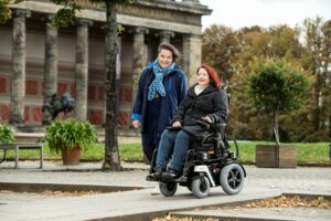 Roodharige vrouw rijdt met een elektrische rolstoel